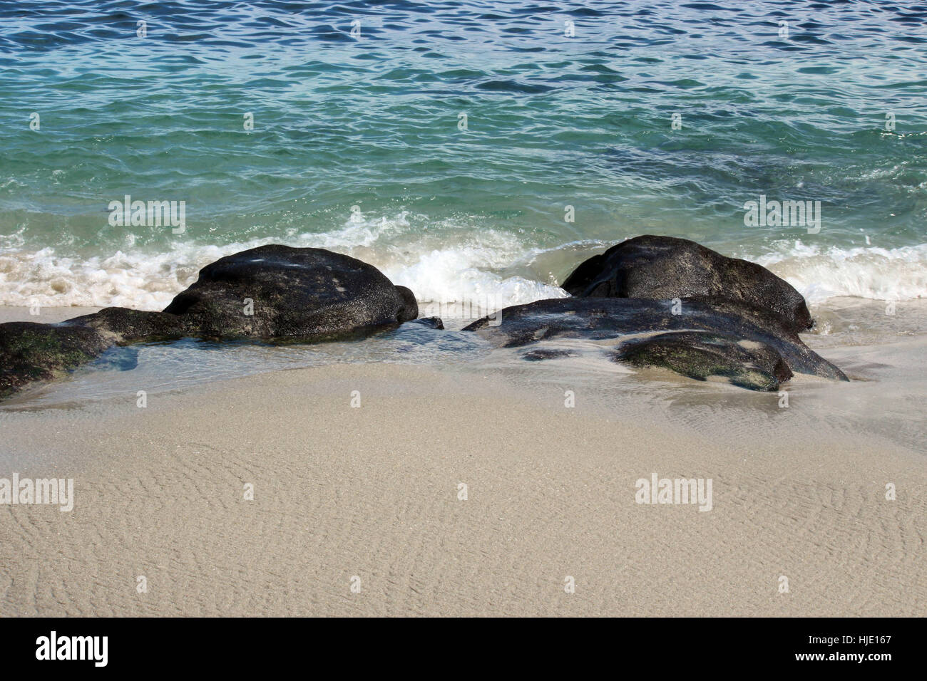 Bianco litorale sabbioso con parzialmente sommerso rocce nel verde blu delle acque dell'Oceano Pacifico a La Jolla, California, Stati Uniti d'America Foto Stock