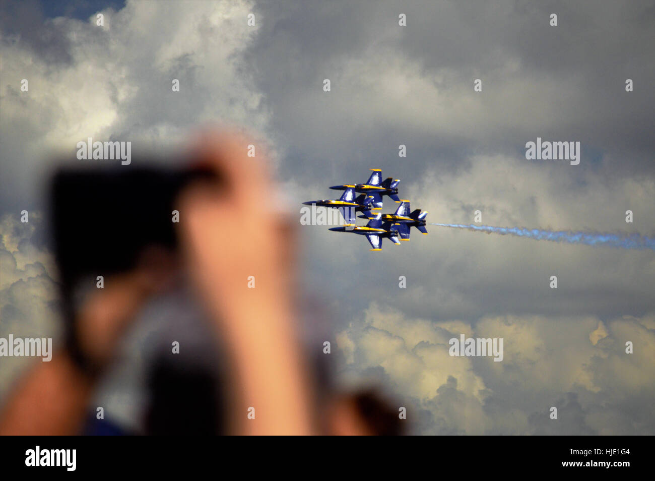 Un uomo con un iphone per scattare una foto del blue angel esecutori di getto come si vola da. Foto Stock