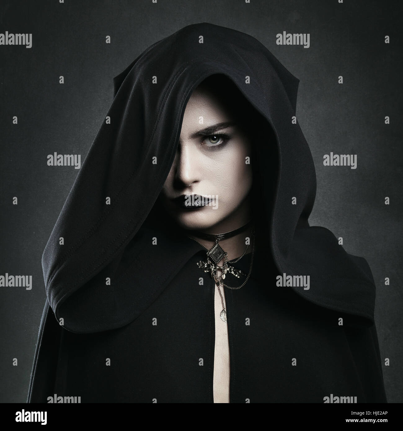 Vampiro bellissimo donna con mantello nero . Halloween e horror Foto Stock