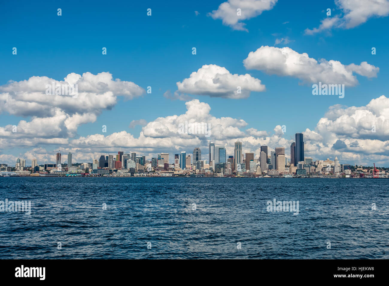 Puffy bianche nuvole passare il puntatore del mouse sopra la skyline di Seattle in una giornata di sole. Foto Stock