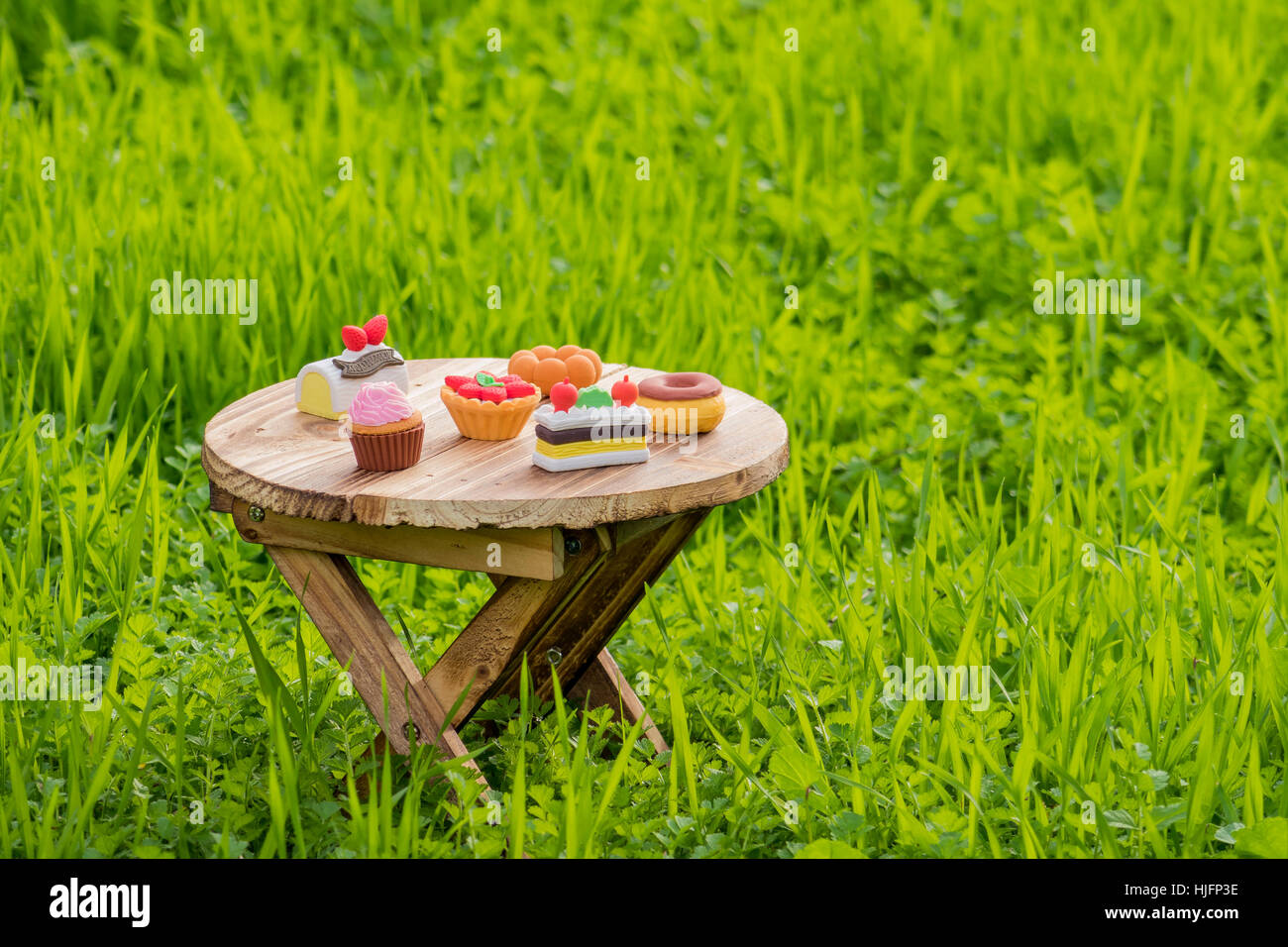 Carino torta eraser parte messo in un tavolo di legno nel campo di erba Foto Stock