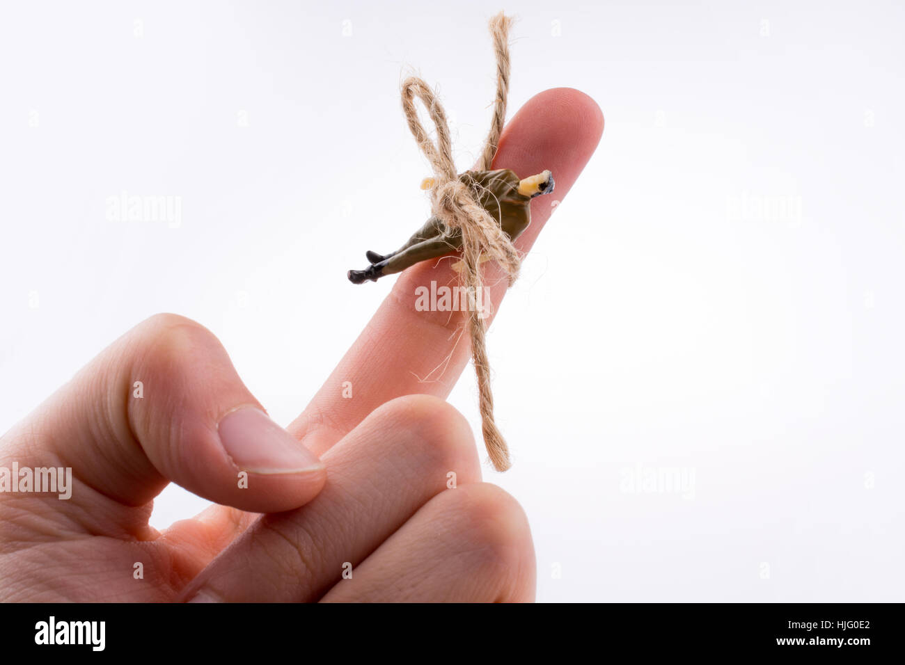 Figura umana legata a una mano su uno sfondo bianco Foto Stock