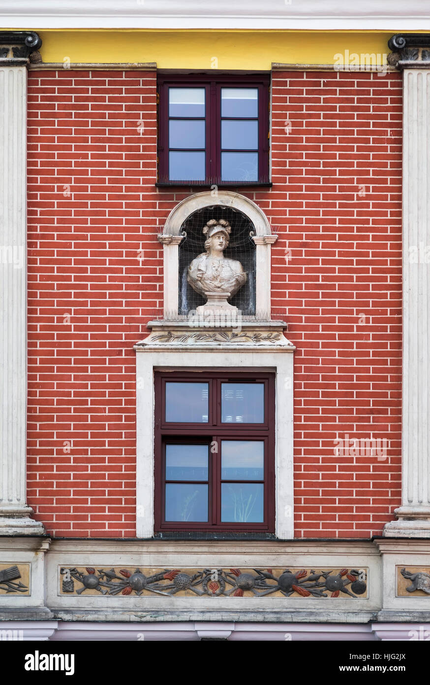 Muro di mattoni di una casa con una nicchia e busto Foto Stock
