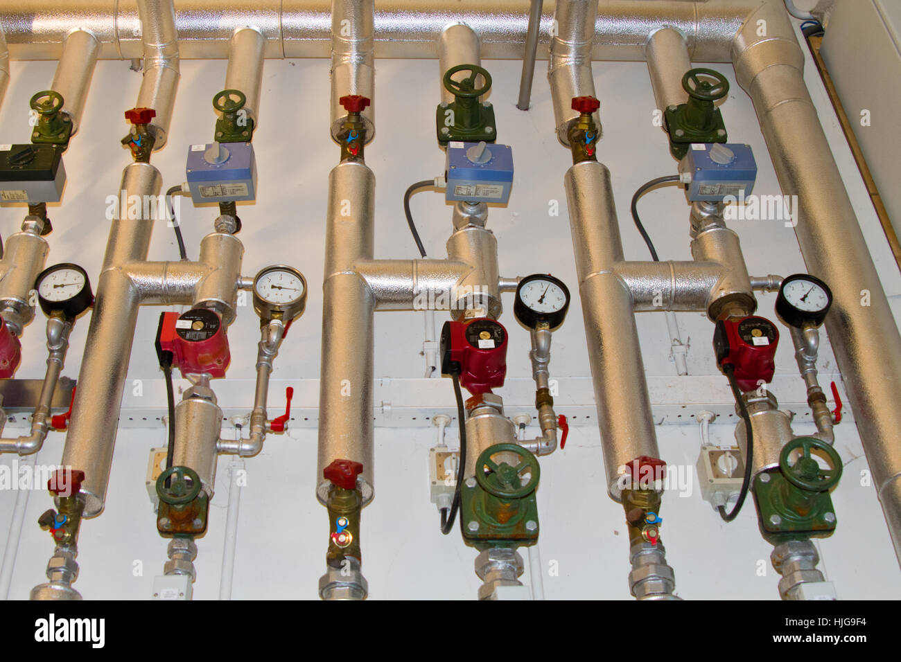 Termometri, manometri, pompe, valvole e interruttori e tubi di un complesso di riscaldamento centrale Foto Stock