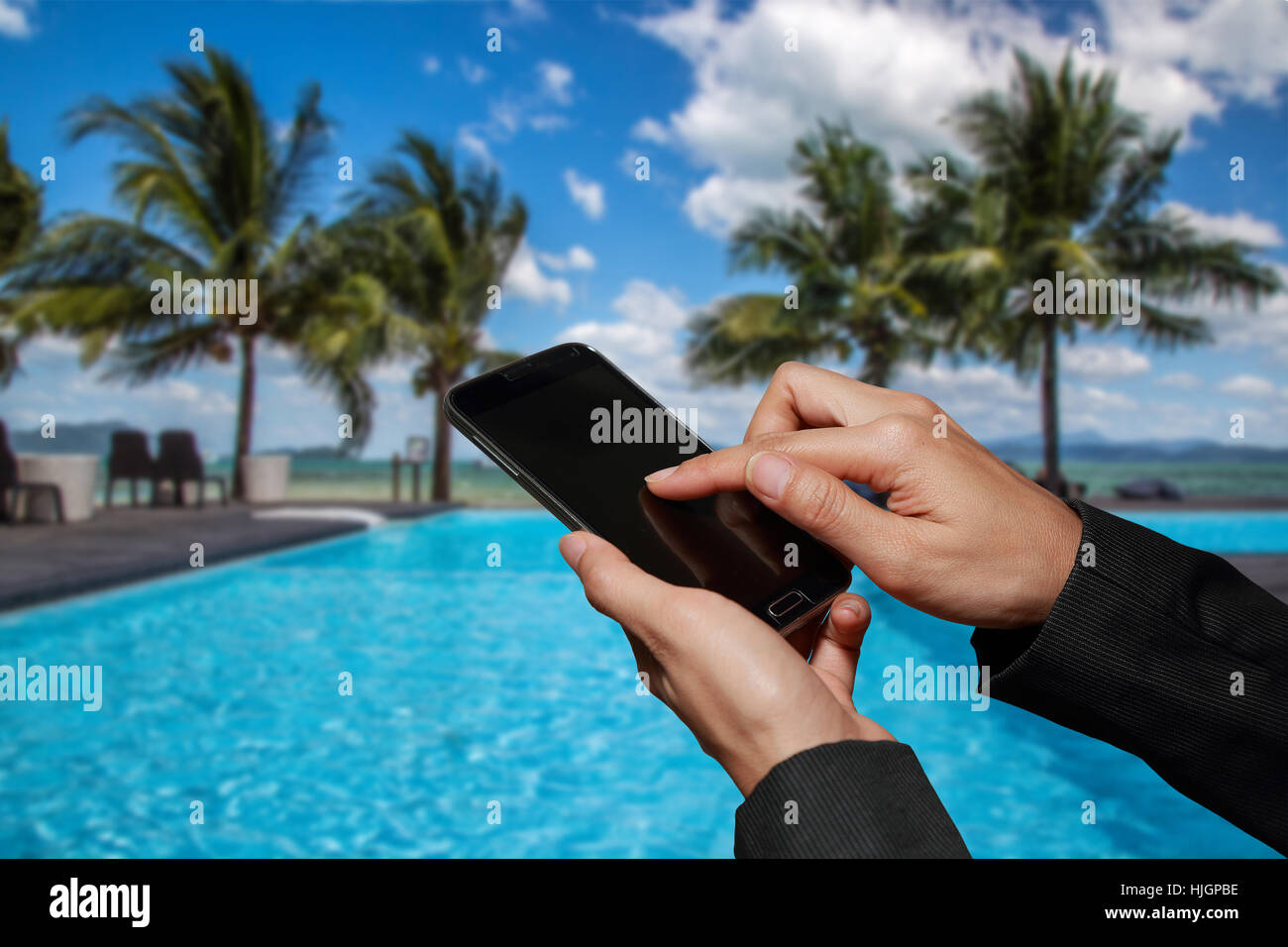 Donna tenere in mano e il touch screen smart phone, cellphone su abstract sfocata la spiaggia dello sfondo. Foto Stock