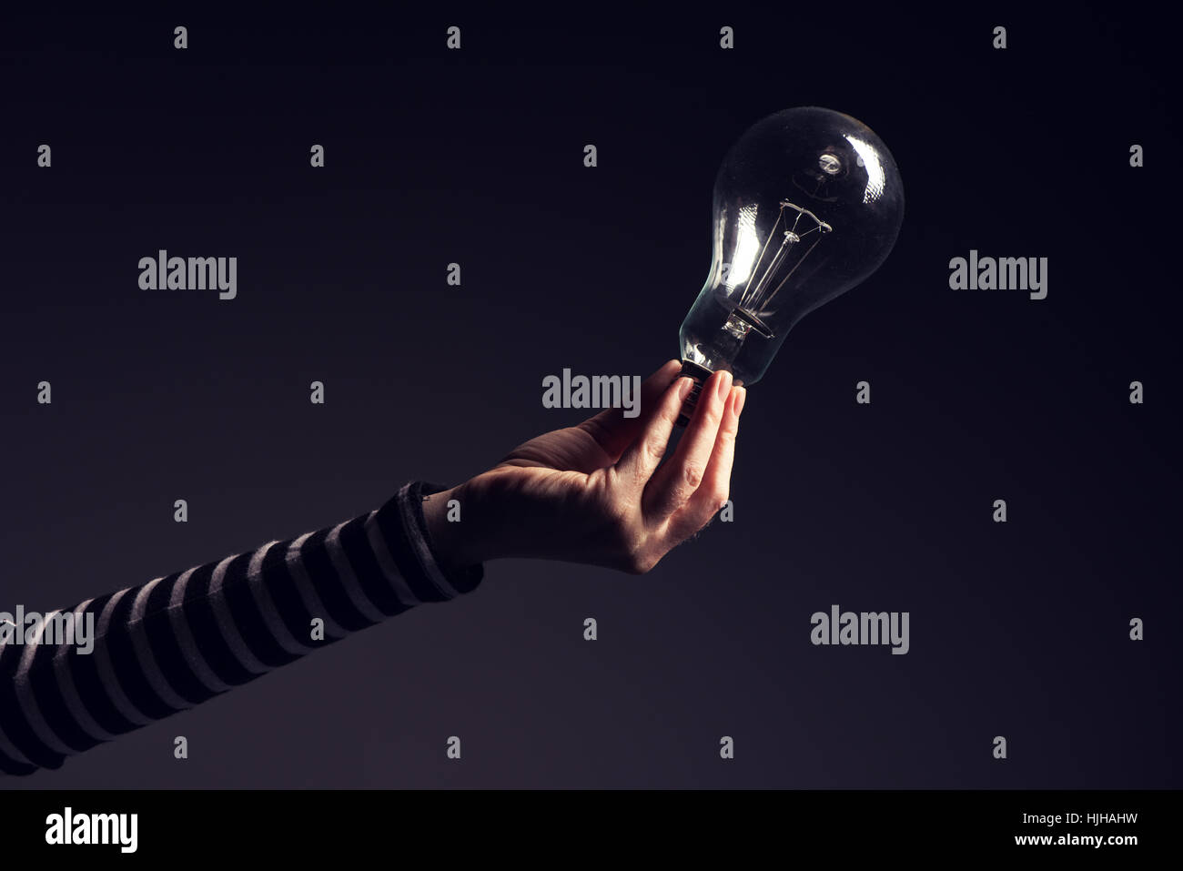 Lampadina della luce in mano femminile, nuove idee e pensiero creativo concept Foto Stock