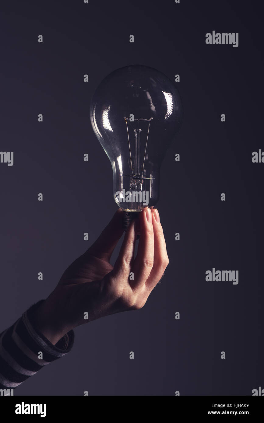 Lampadina della luce in mano femminile, nuove idee e pensiero creativo concept Foto Stock