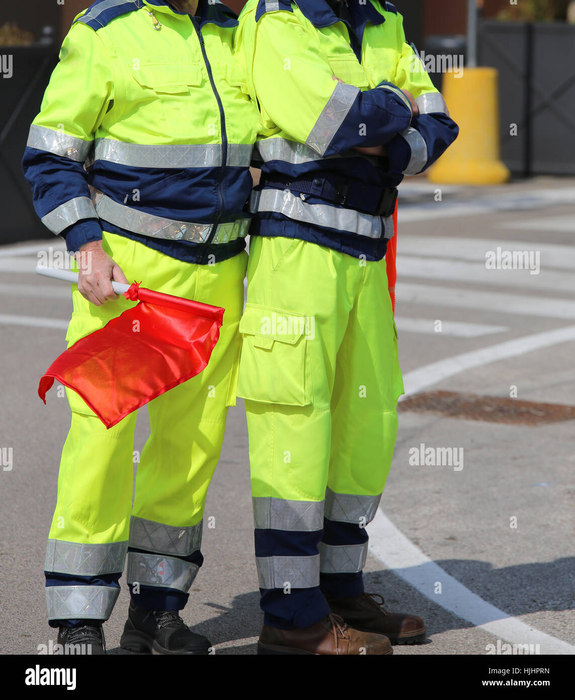 Due uomini della protezione civile italiana con vistose uniforme e la bandiera rossa per segnalare il pericolo Foto Stock