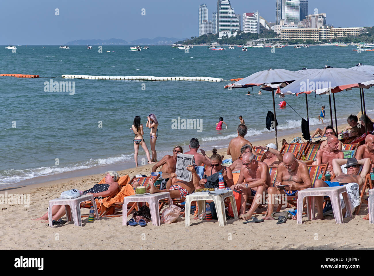 Turisti prendere il sole sulla spiaggia di Pattaya, Thailandia turismo sud-est asiatico Foto Stock