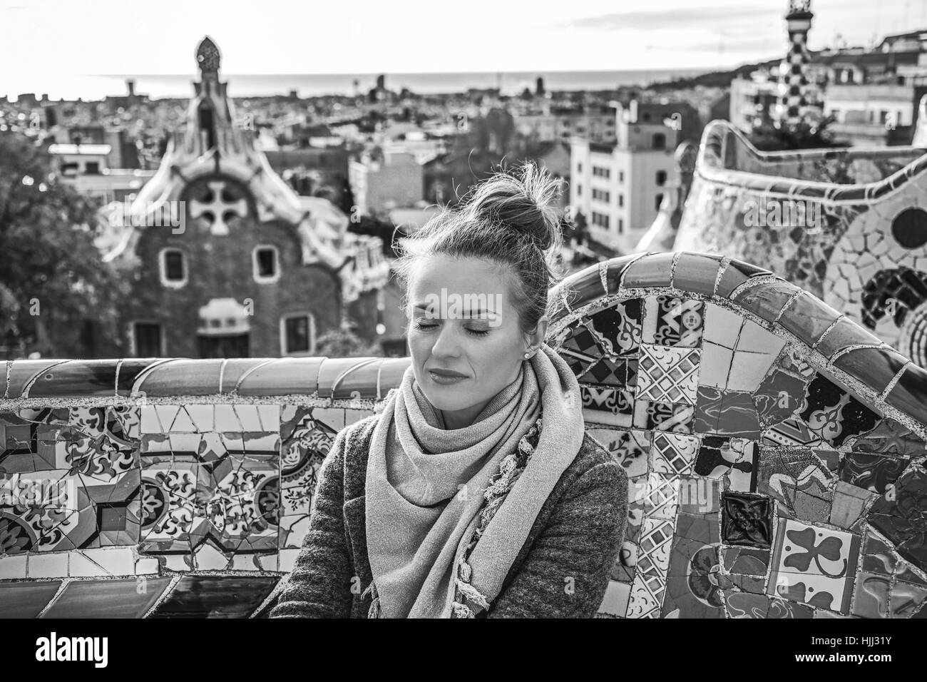 Firma di Barcellona. in stile moderno e rilassato la donna a ricoprire a Parco Guell a Barcellona Spagna seduta sul banco di lavoro Foto Stock