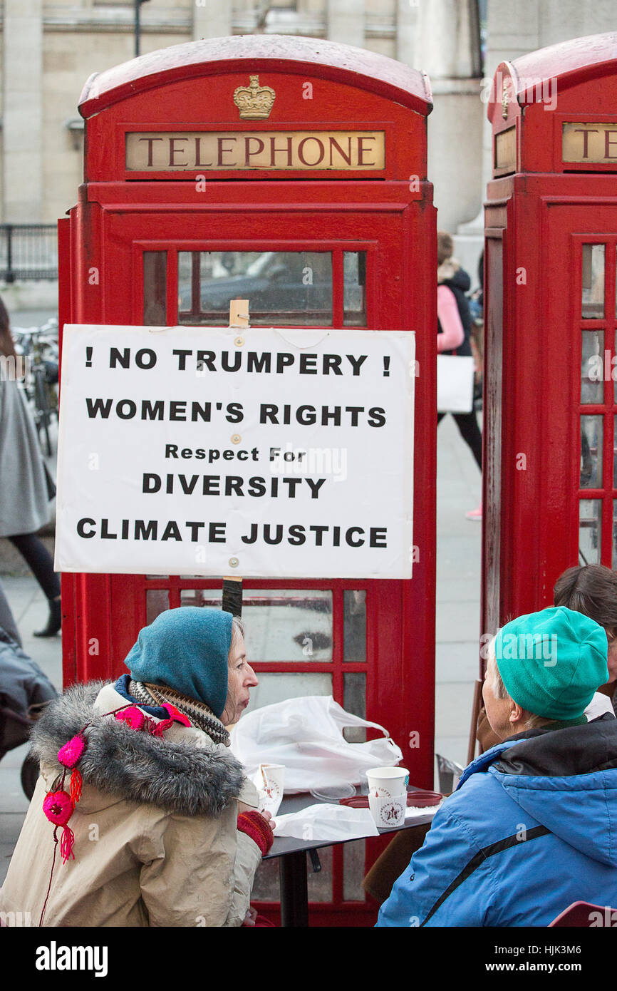 Donna avente una rottura vicino iconico red phone booth vicino a Trafalgar Square durante l'anti Trump donna marzo a Londra. Foto Stock