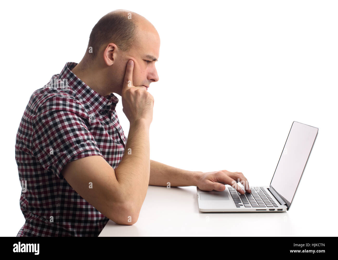 Considerato l uomo al lavoro sul suo computer portatile. Vista laterale Foto Stock