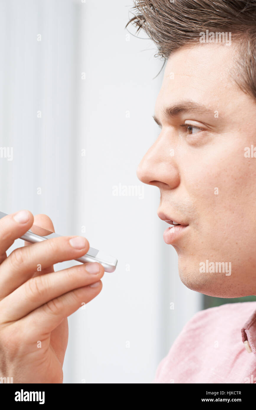 Uomo che utilizza la comunicazione vocale su Internet la tecnologia di ricerca sul telefono cellulare Foto Stock