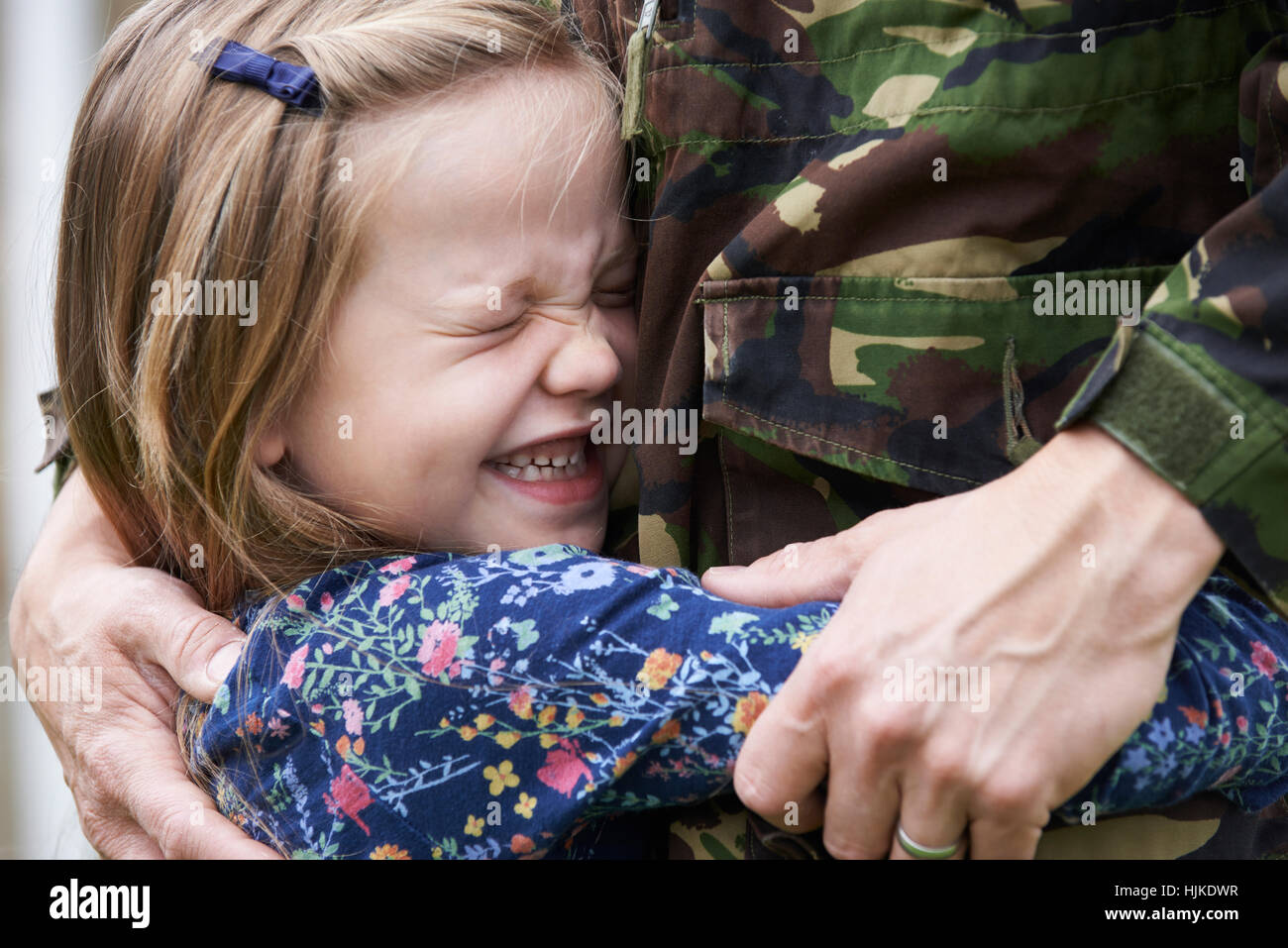 Soldato in congedo essendo abbracciato dalla figlia Foto Stock