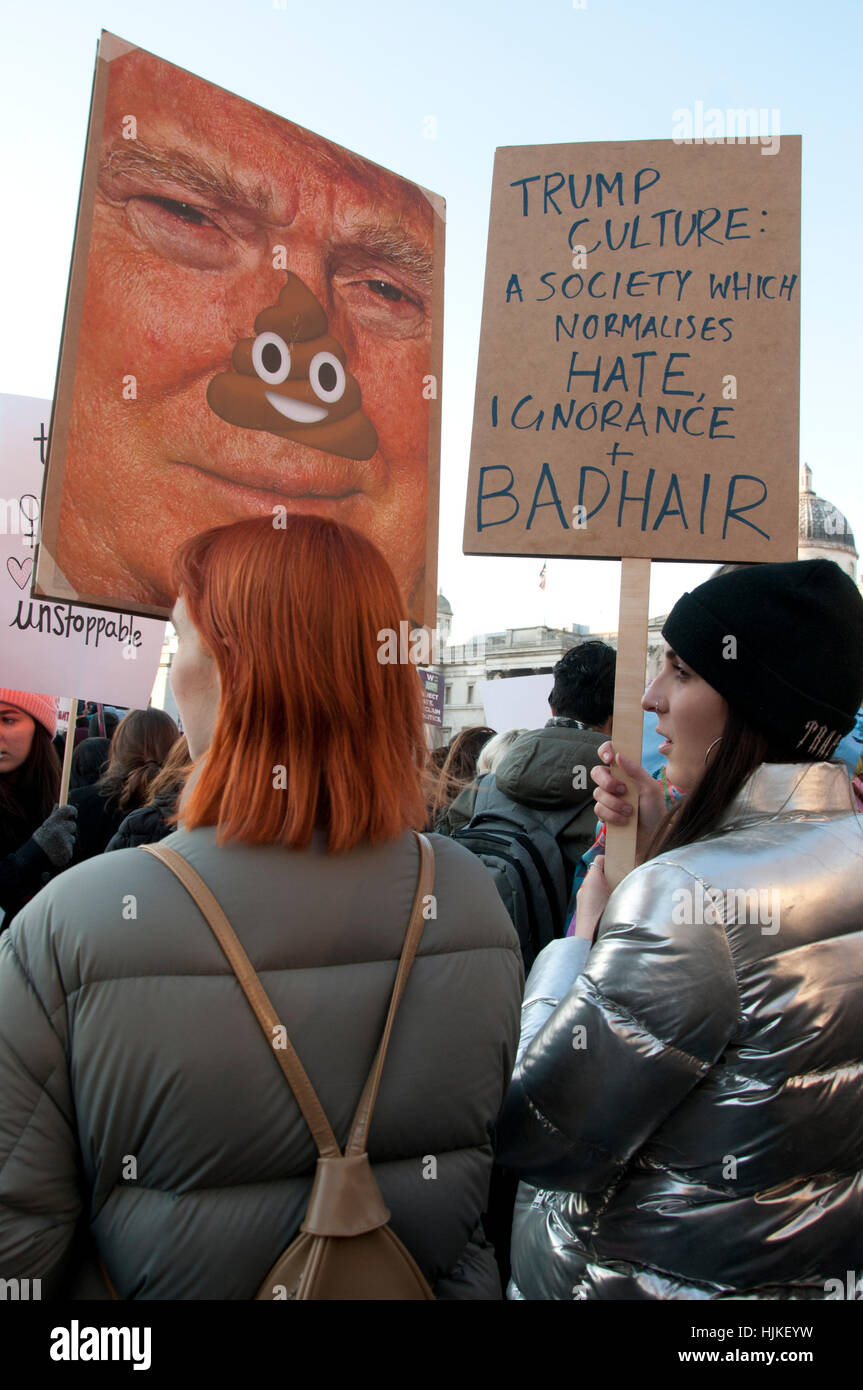 Un rosso donna dai capelli detiene un caricatured foto di Donald Trump con naso coperto da escrementi Foto Stock