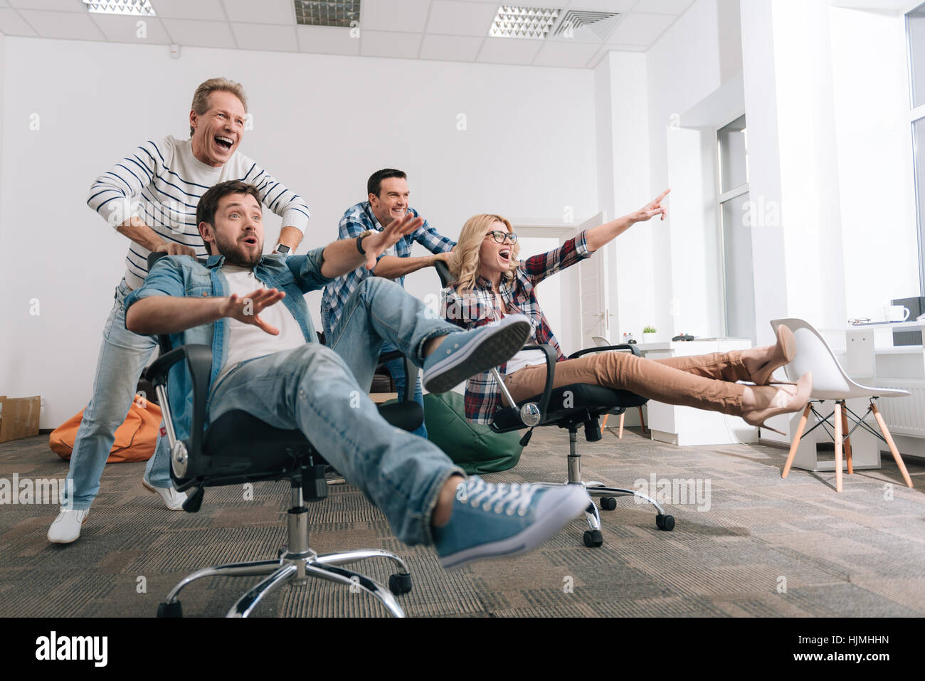 Gioiosa felice la gente seduta in sedie da ufficio Foto stock - Alamy