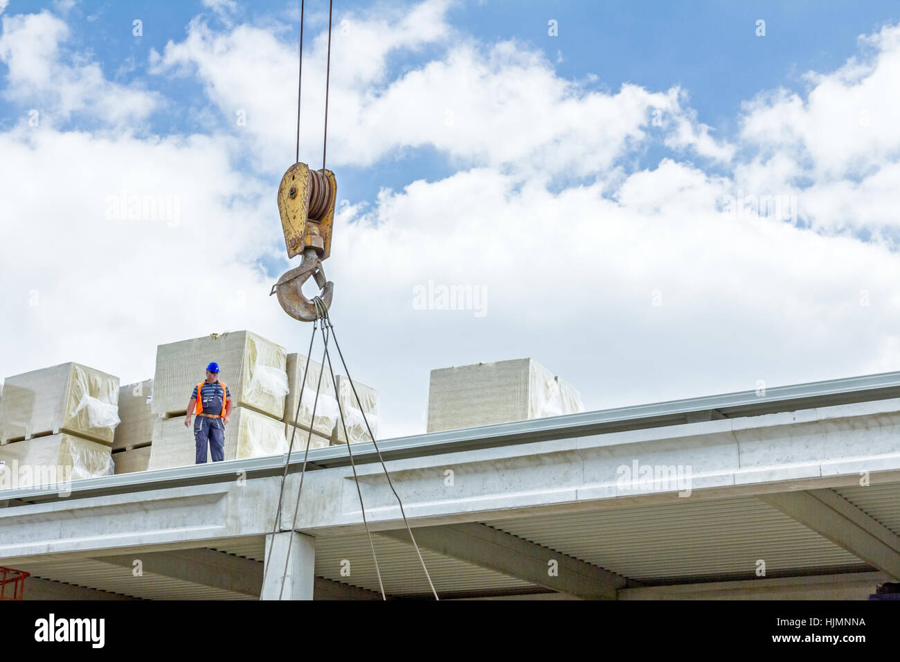 Gru mobile è in fase di caricamento del carico. Vista sul sito di costruzione di macchinari, la gente al lavoro. Foto Stock