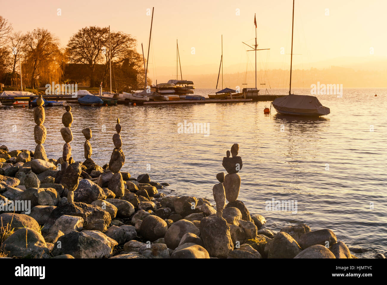 In riva al lago di Zurigo pietre equilibrata tramonto Foto Stock