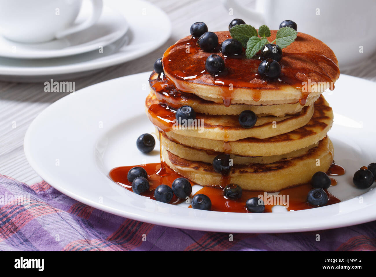 American Pancake con mirtilli e sciroppo d'acero su una piastra bianca orizzontale Foto Stock