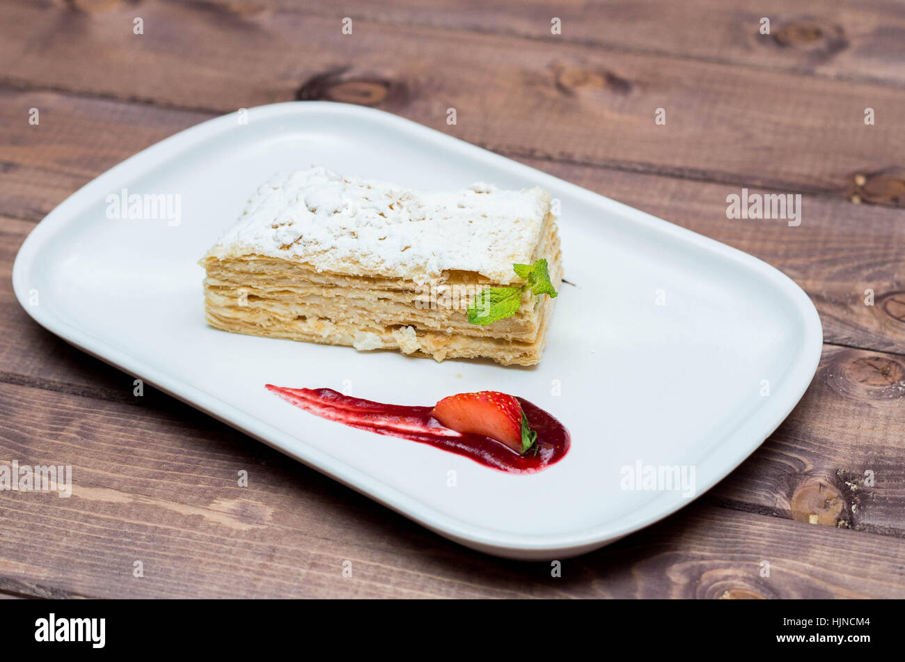 Bella e deliziosi dessert millefoglie con frutti di bosco su una piastra bianca con salsa, bellissimo ristorante offerta Foto Stock