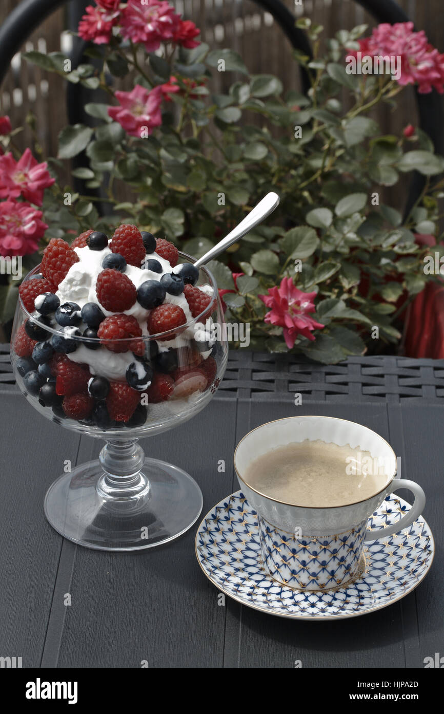 Panna con frutti di bosco e caffè sulla terrazza Foto Stock