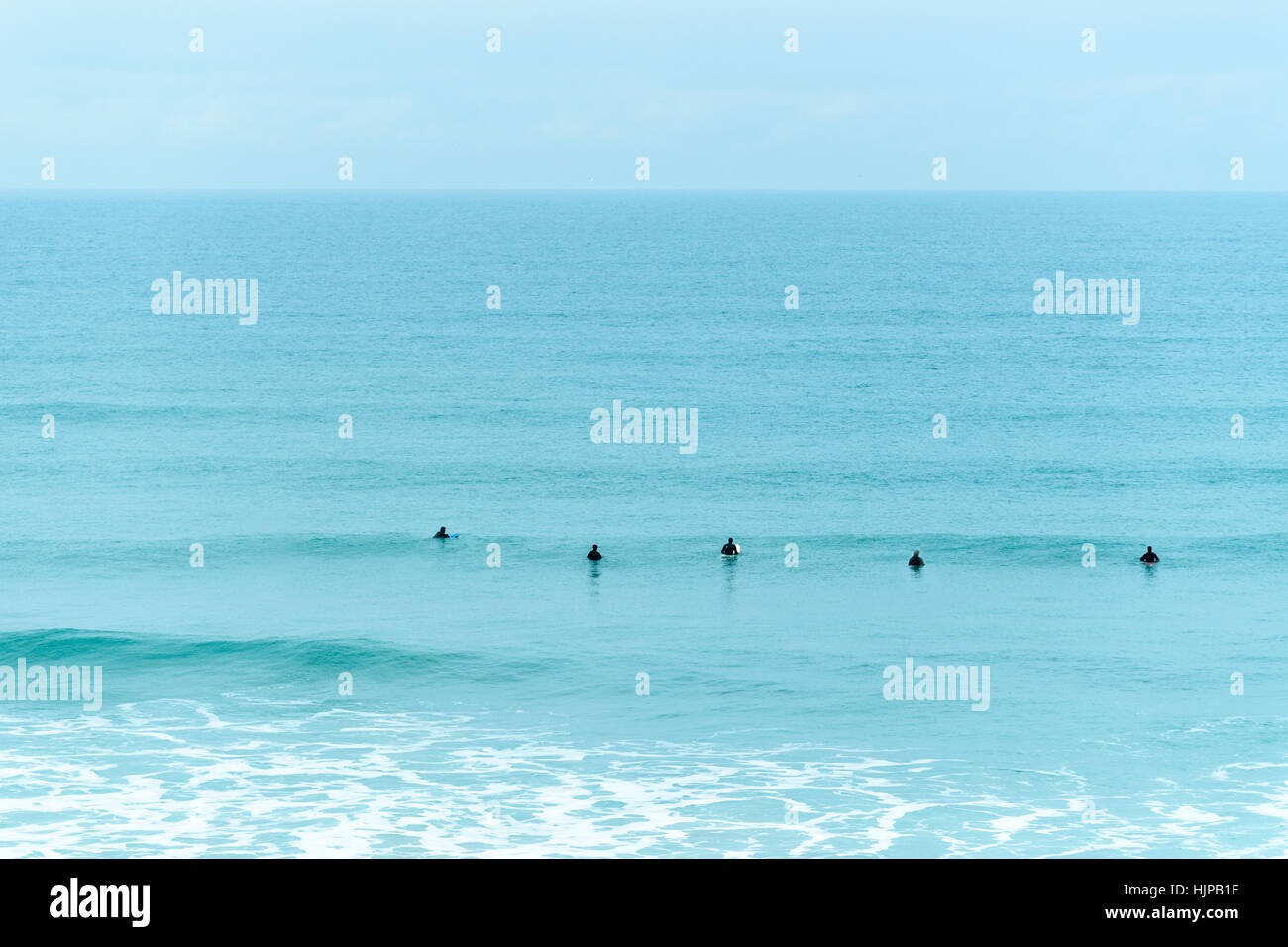 Attesa per il surf a Watergate, Cornwall. Foto Stock
