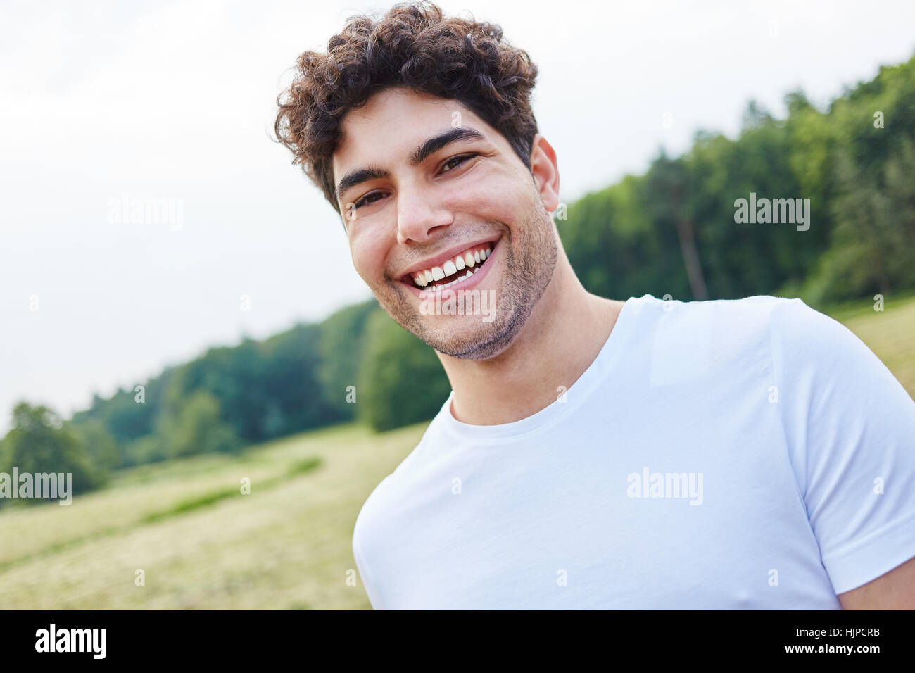 Atleta giovane uomo ridendo di gioia al parco Foto Stock