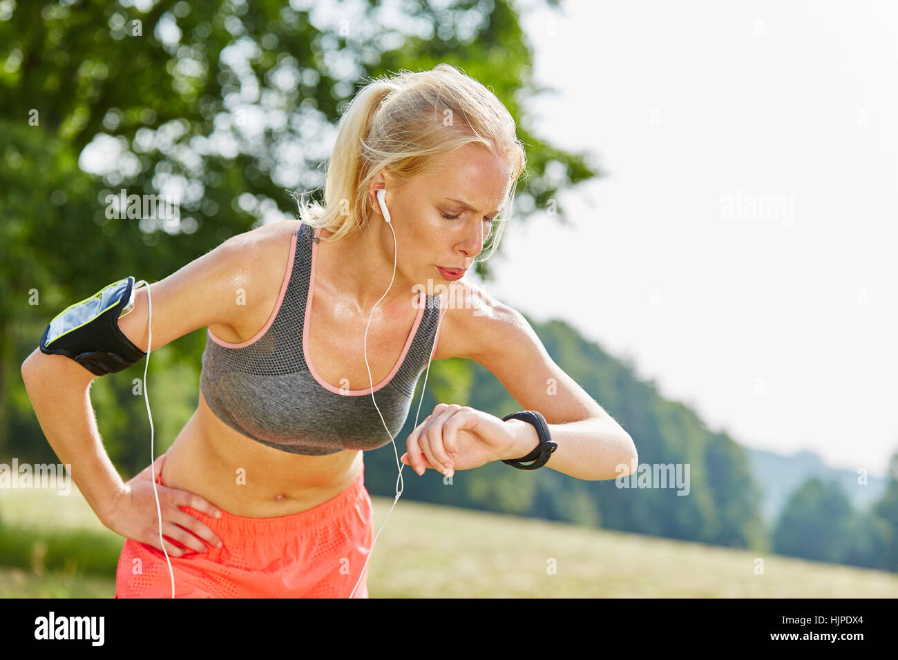 La donna controlla le prestazioni con tracker dopo un allenamento fitness Foto Stock