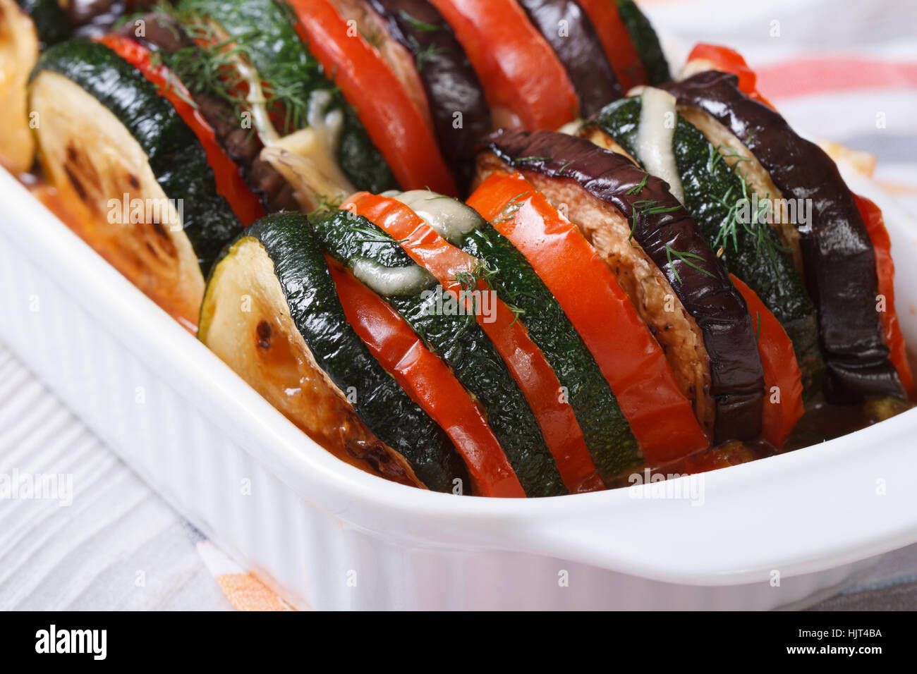 Melanzane, zucchine e pomodori al forno con formaggio ed erbe closeup orizzontale Foto Stock