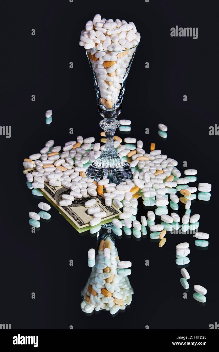 La droga e il denaro nel deserto di vetro. Legal Prescription Drugs rappresentato con la moneta degli Stati Uniti su sfondo con mirroring. Foto Stock