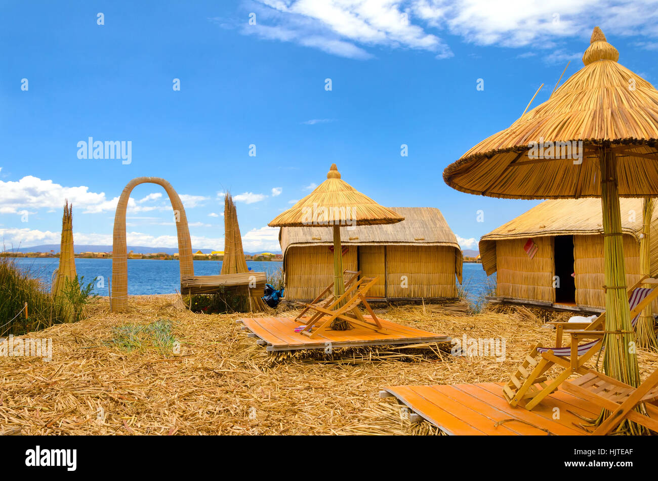 Gli ombrelloni e gli edifici su uno degli Uros isole galleggianti sul lago Titicaca in Perù Foto Stock