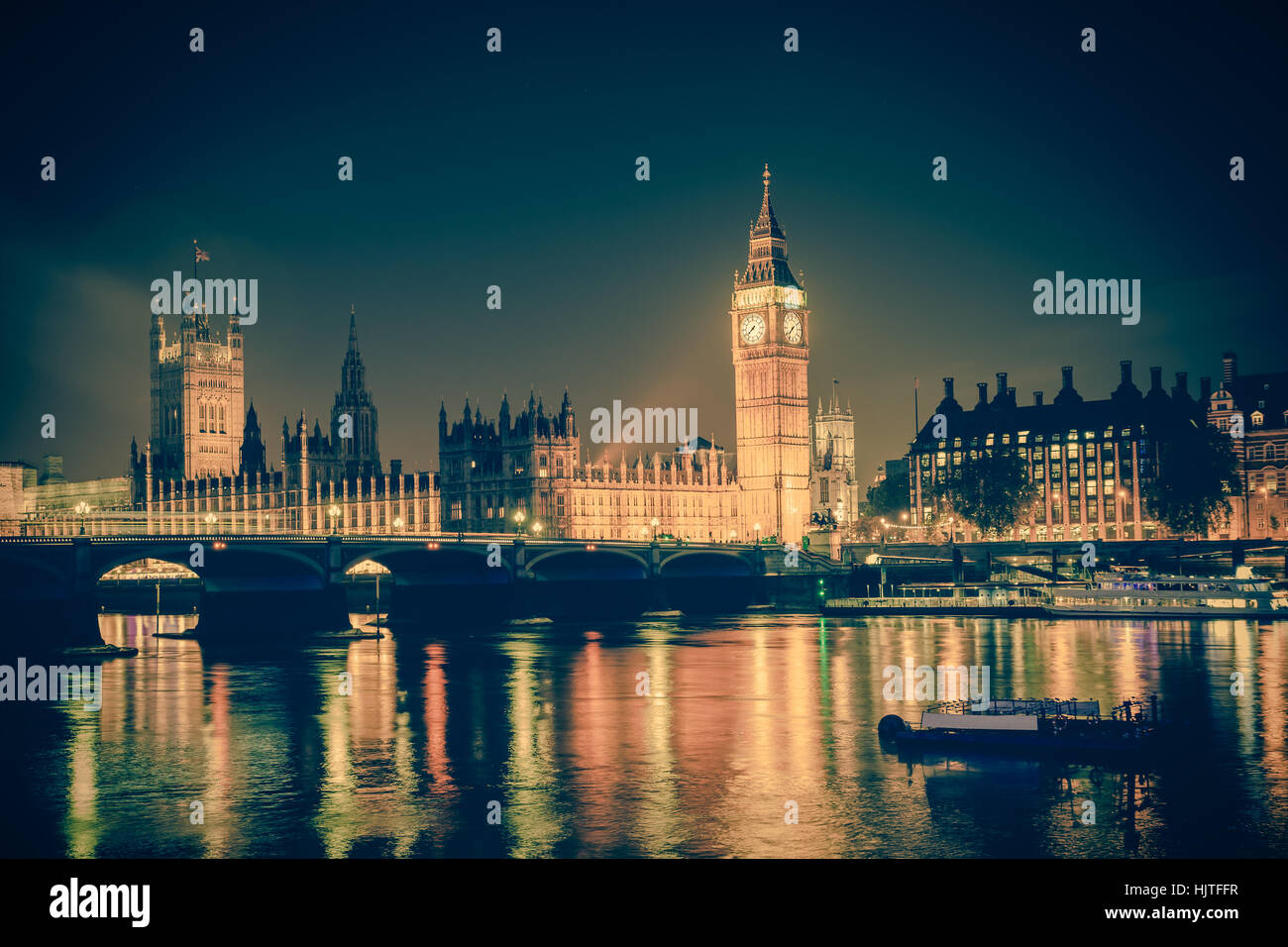 Vista iconica Westminster con il Big Ben, la Casa del Parlamento e il Tamigi a Victoria Embankment illuminata di notte con tono vintage. Foto Stock
