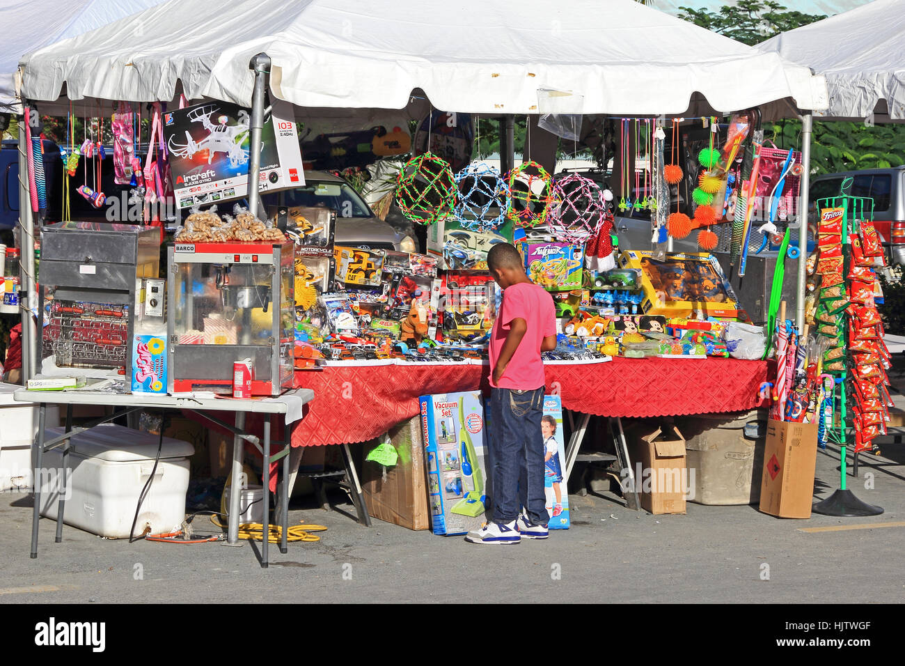 Ragazzo che guarda a giocattoli sul mercato, di stallo Road Town, Tortola Foto Stock