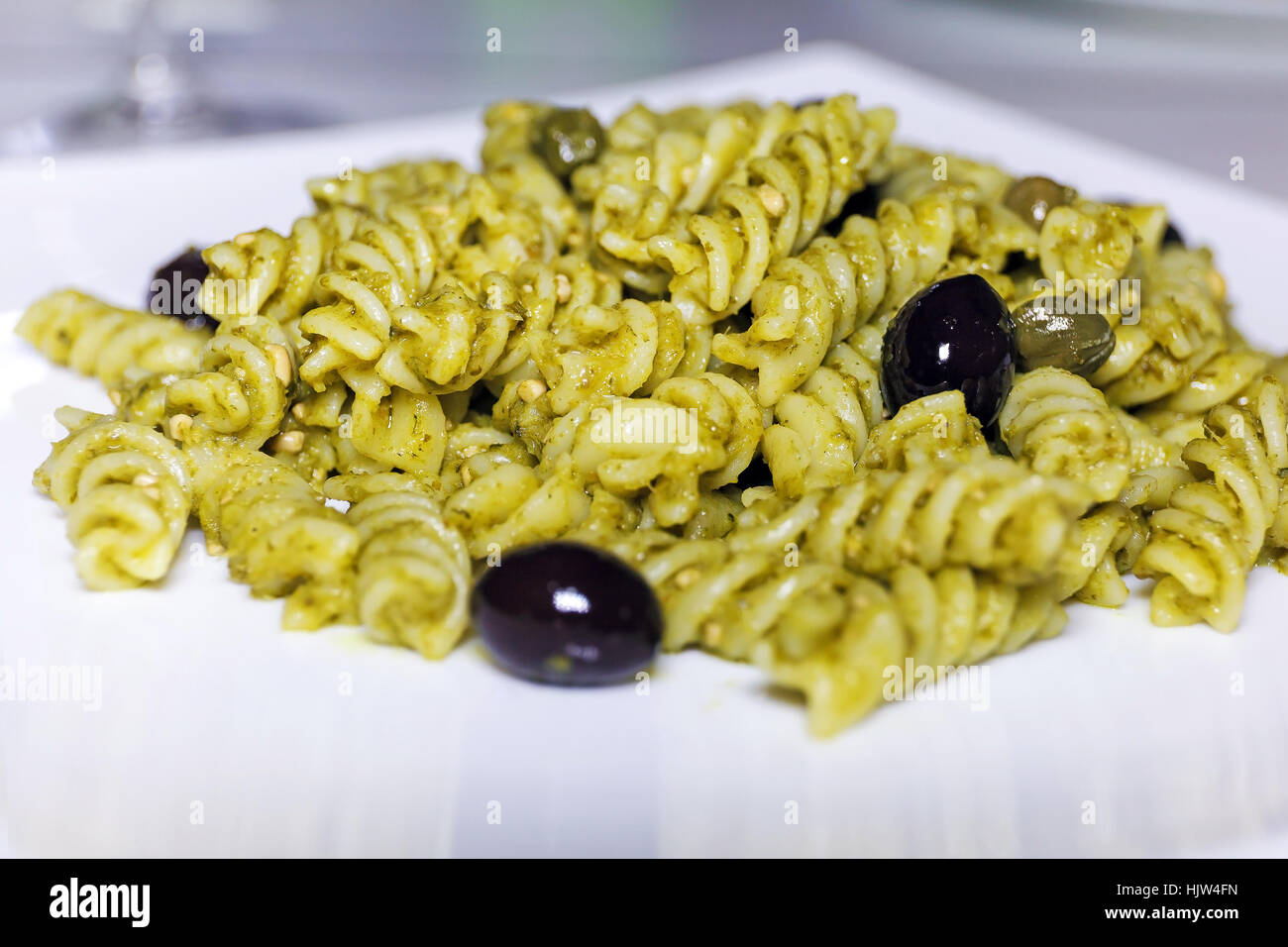 Fusilli conditi con il pesto, olive nere e capperi. Pasto pronto da mangiare Foto Stock