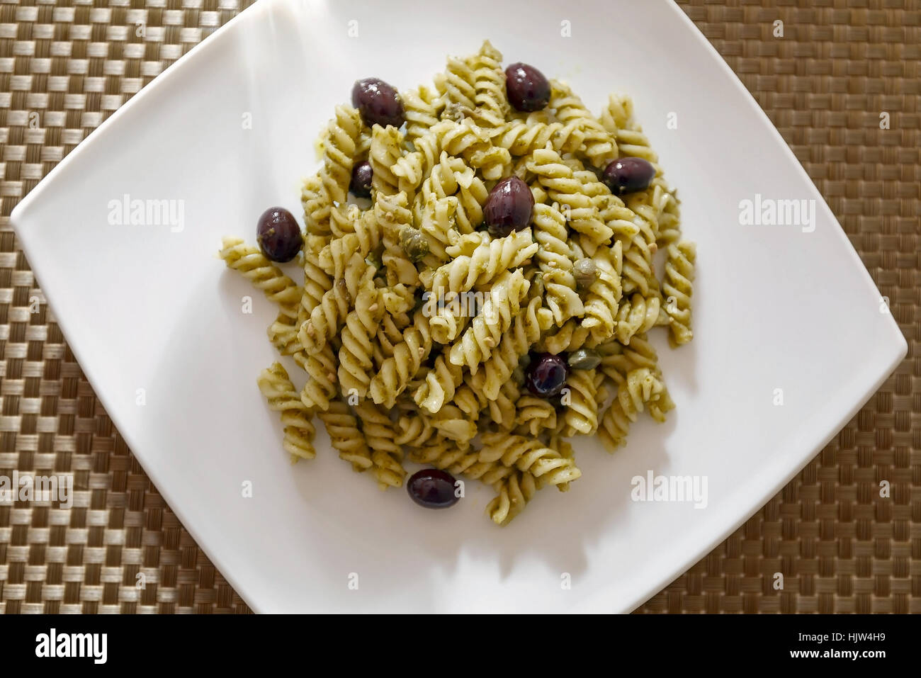 Fusilli conditi con il pesto, olive nere e capperi. Pasto pronto da mangiare Foto Stock