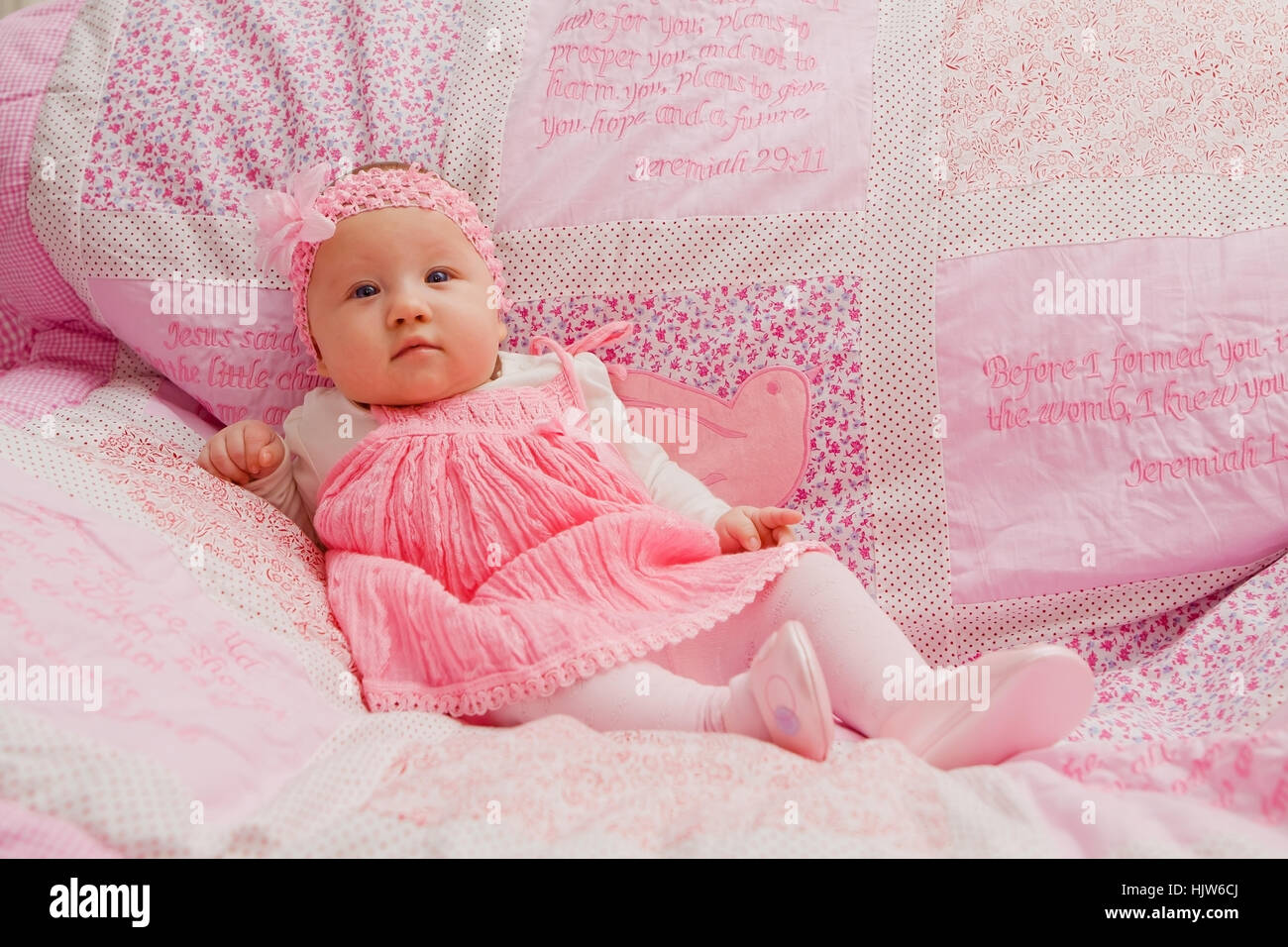 Baby girl sulla coperta rosa con versetti biblici Foto Stock