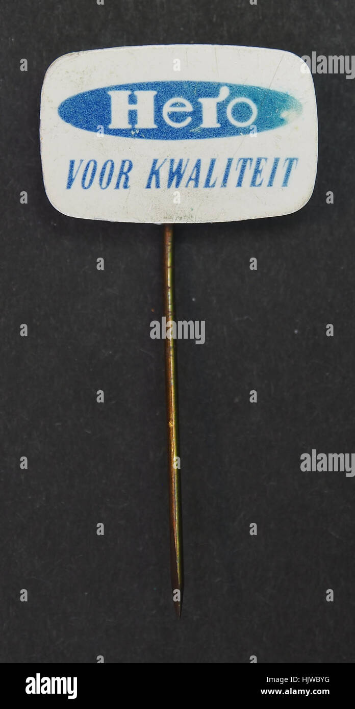 La spilla pubblicitaria Hero è un articolo promozionale vintage utilizzato per commercializzare il marchio Hero, in particolare per i suoi prodotti alimentari come marmellate e conserve. Rappresenta la strategia di marketing e branding alimentare della metà del XX secolo. Foto Stock