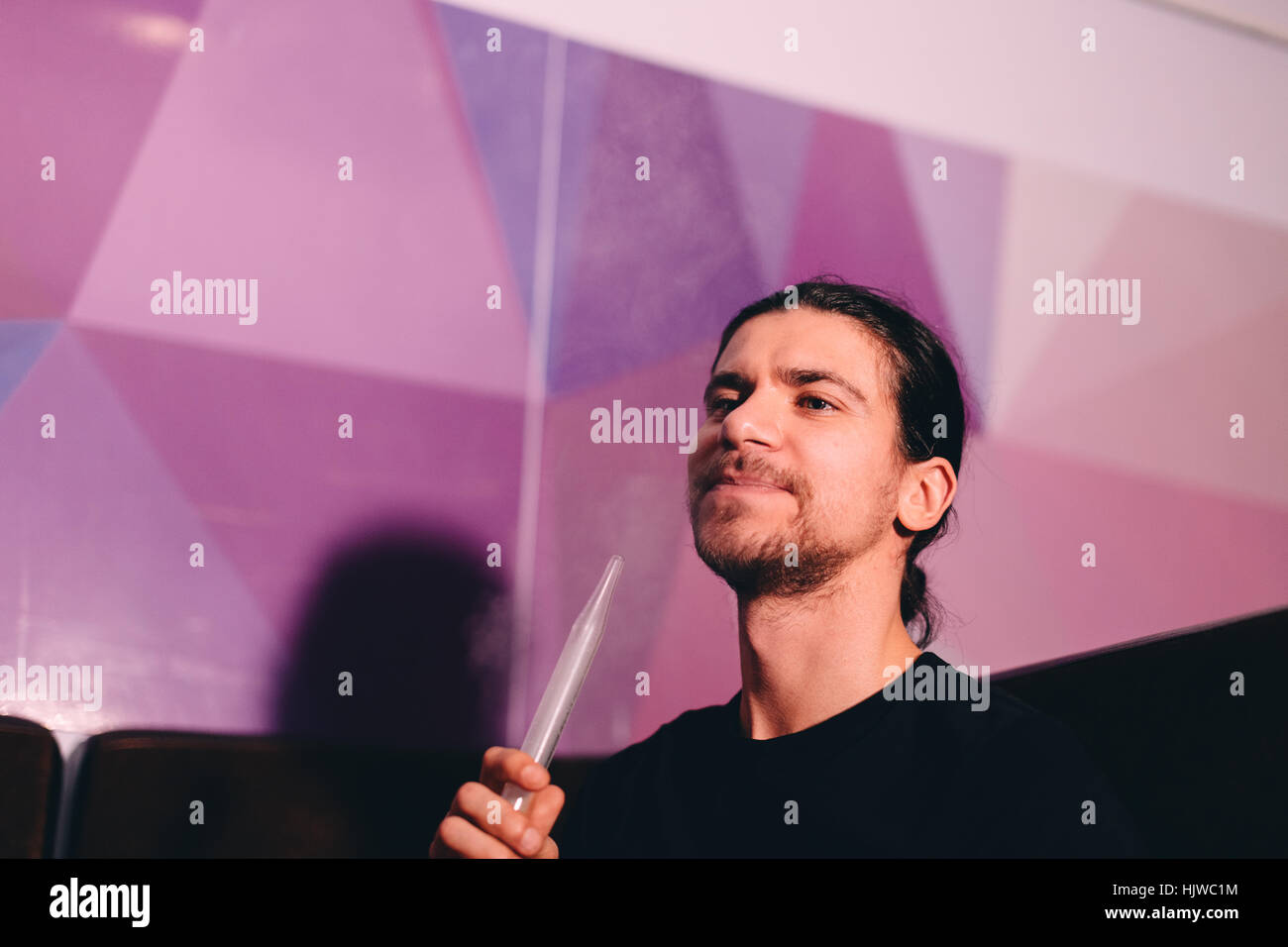 Uomo con narghilè tubo Foto Stock