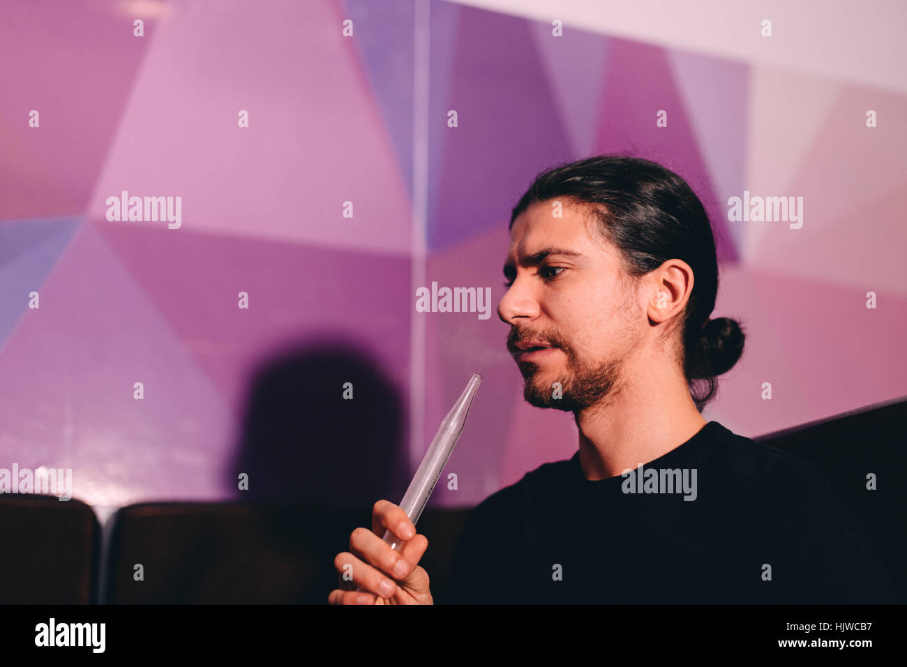 Uomo con narghilè tubo Foto Stock