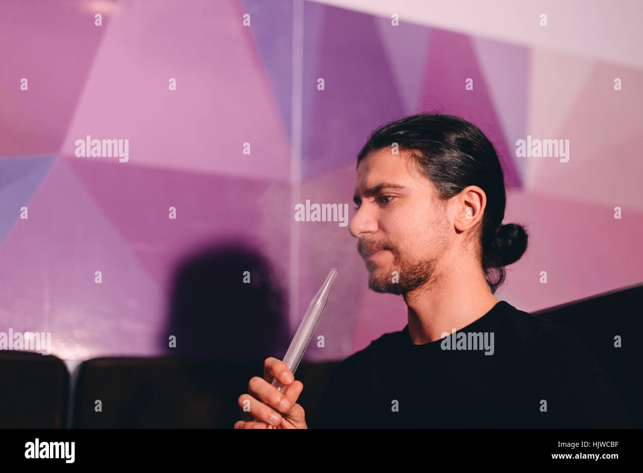 Uomo con narghilè tubo Foto Stock