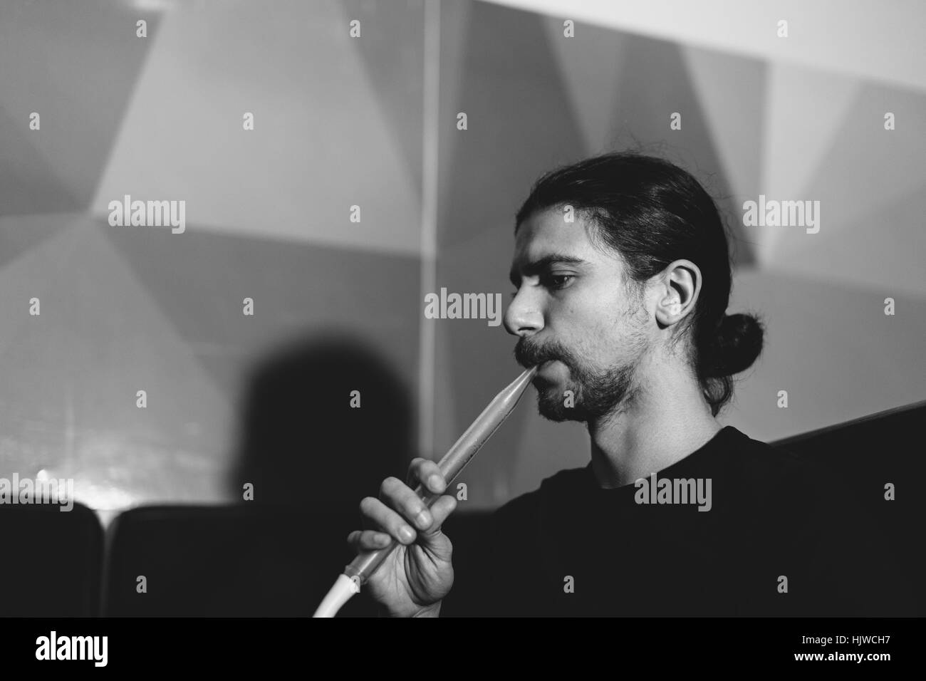 Uomo con narghilè tubo Foto Stock