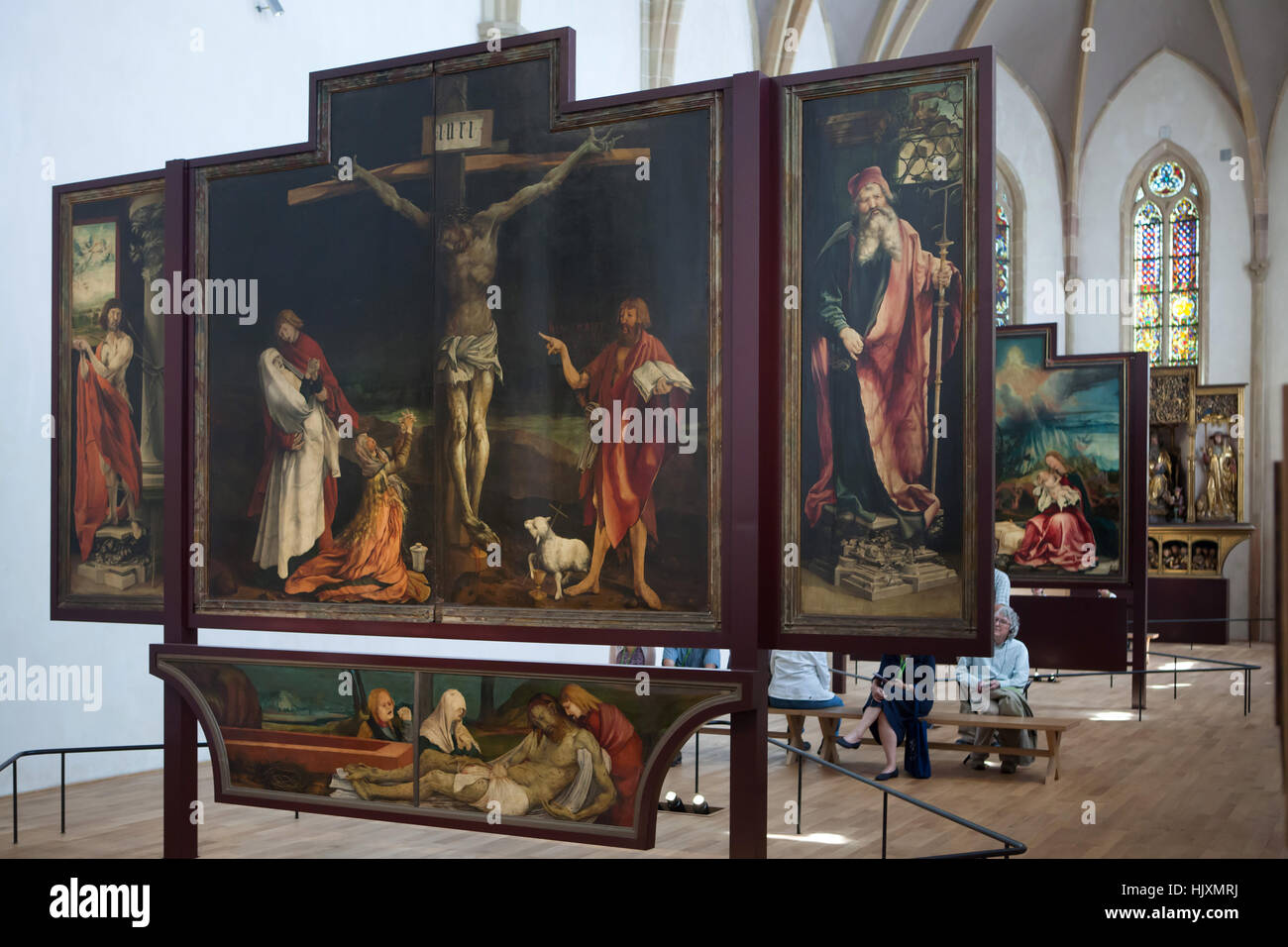 I visitatori di fronte alla pala Isenheim (1512-1516) da artista del Rinascimento tedesco Matthias Grunewald visualizzato nel Musee d'Unterlinden (museo Unterlinden) di Colmar, Alsazia, Francia. A prima vista di Isenheim pala con Crocifissione incorniciato dal martirio di San Sebastiano sulla sinistra e da San Antonio il Grande sulla destra. Foto Stock