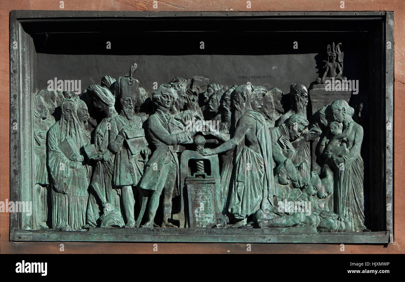 Rilievo bronzeo dedicata ai vantaggi della stampa di libri per l'Asia sul monumento a Johannes Gutenberg (1840) da scultore francese David d'Angers a Strasburgo, Alsazia, Francia. Filologo britannico William Jones (L) e Francese Indologist Abraham Hyacinthe Anquetil-Duperron (R) sono rappresentati accanto alla macchina da stampa in centro. Sultan Mahmud II dell'Impero Ottomano è raffigurato nella parte sinistra circondato dall'Brahmans scambiando i manoscritti per i libri e il popolo cinese Confucio di lettura. Foto Stock