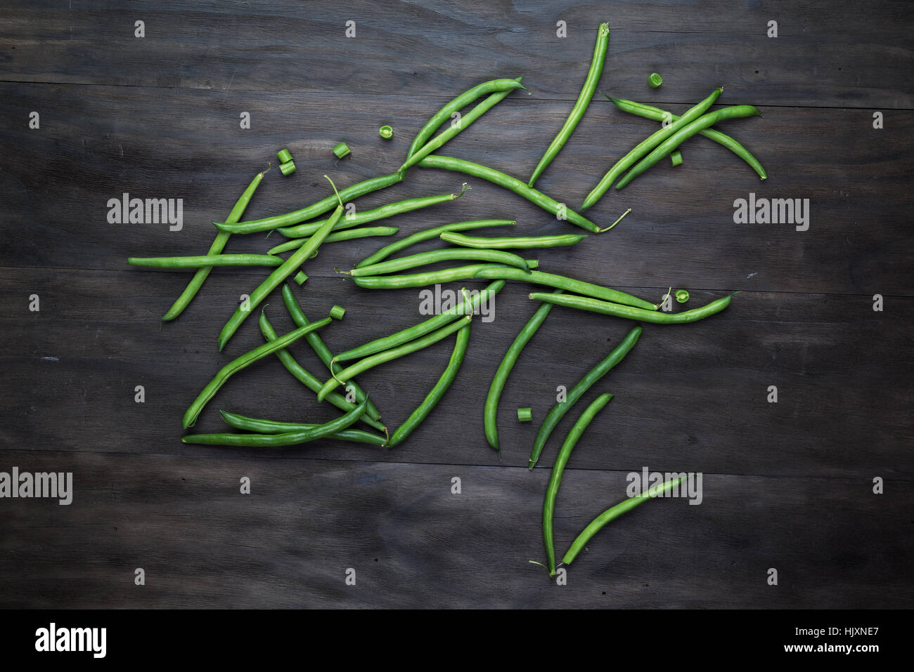 Fagioli verdi stringa su un vecchio legno sfondo nero.Vista dall'alto. Foto Stock