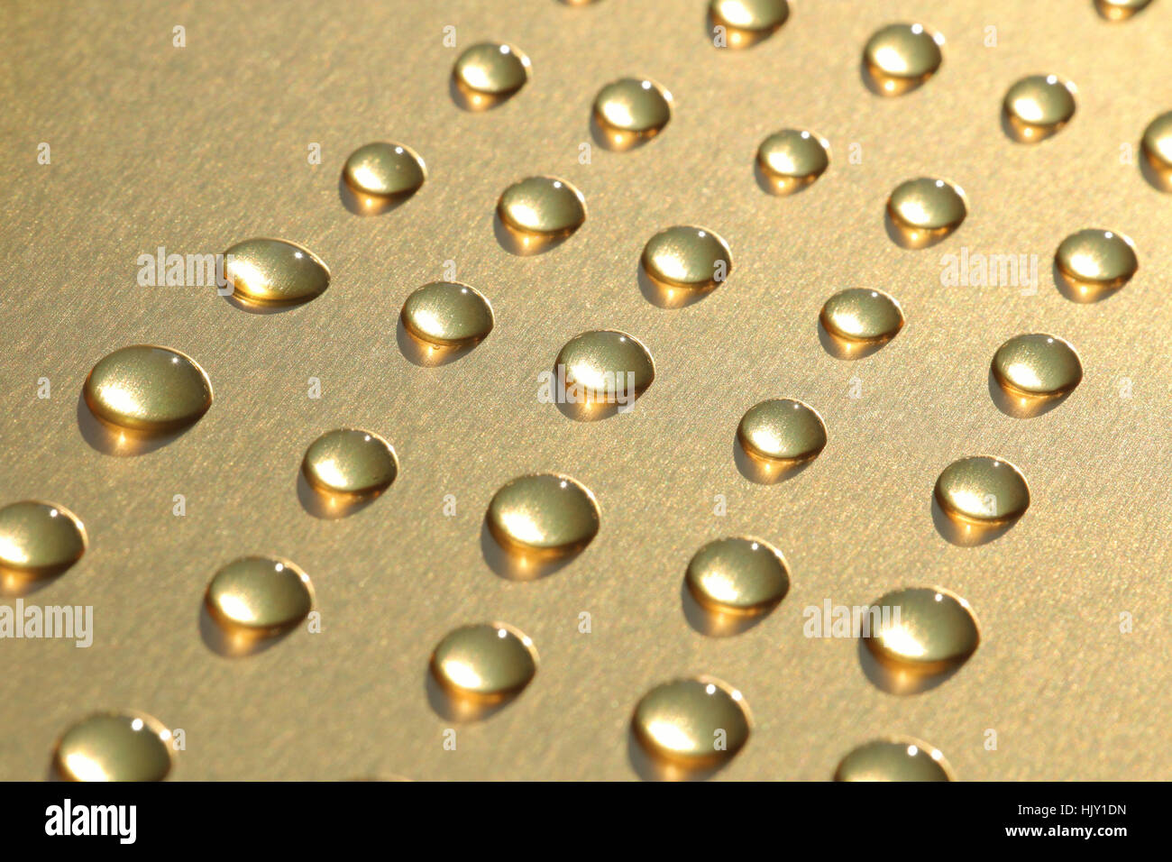 Gocce di rugiada su oro sfondo metallico Foto Stock