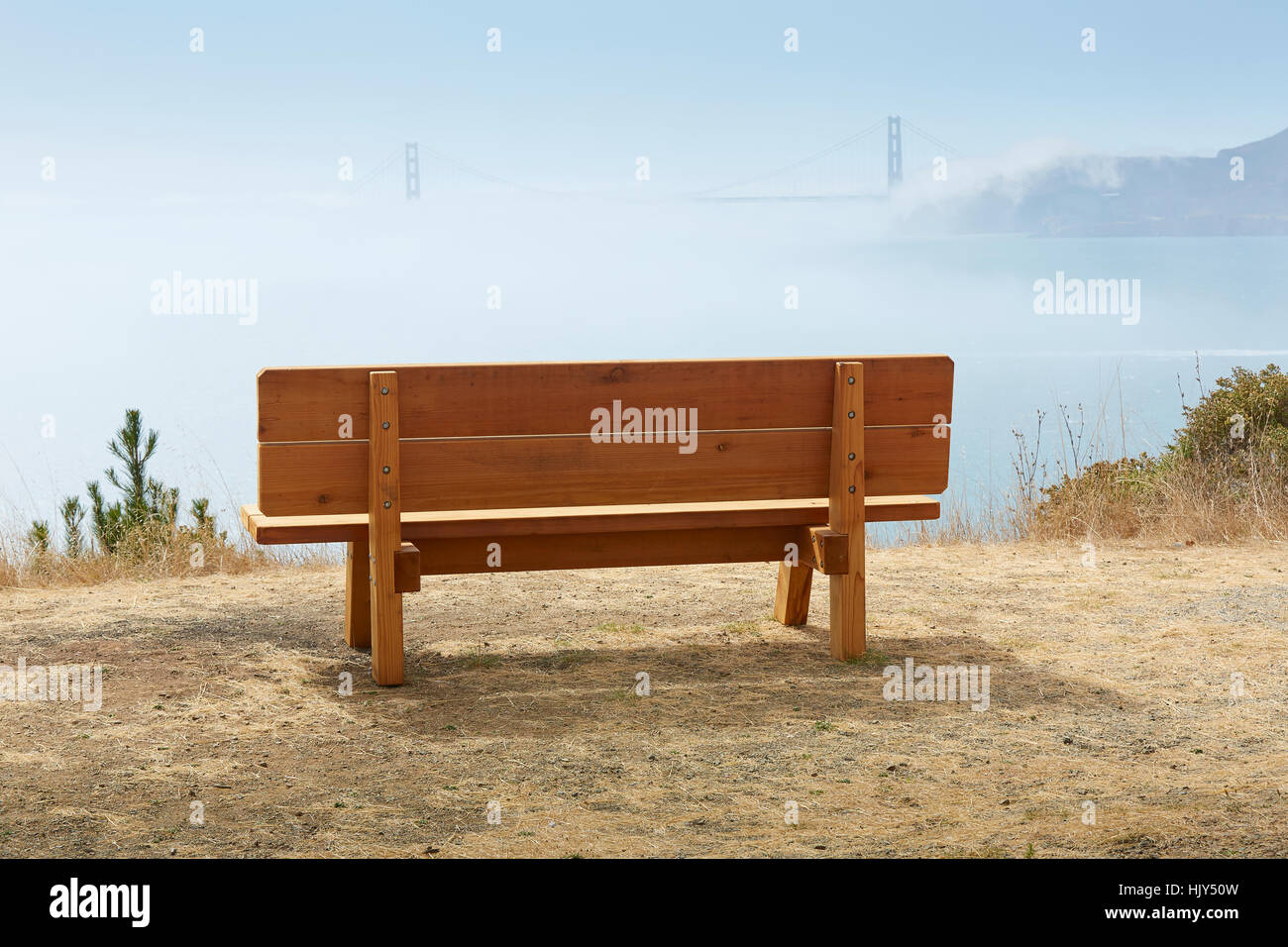 Una panchina nel parco su Angel Island guardando oltre il coperto nebbia la Baia di San Francisco e il Golden Gate Bridge. Foto Stock