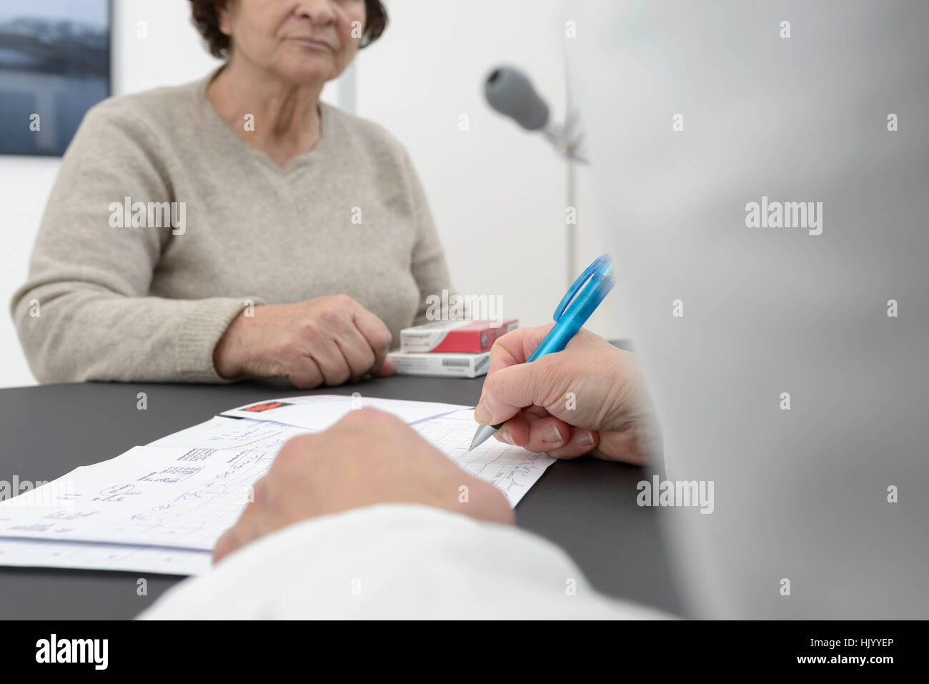 Medico di consulenza paziente-cardiologo anziano paziente-cardiologo spiegare i risultati ECG e prescrivere il farmaco. Foto Stock