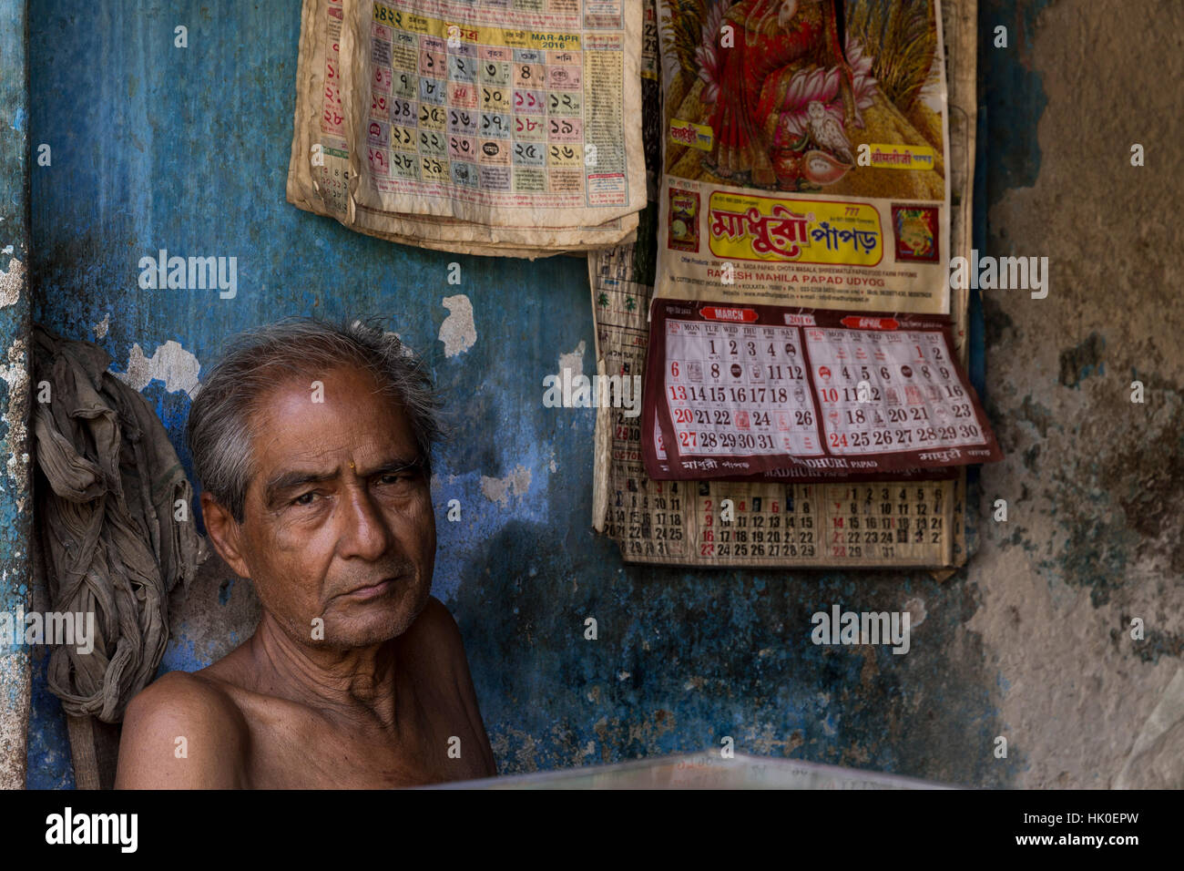 Uomo contro un muro di blu. Kumartuli, Calcutta, West Bengal, India Foto Stock