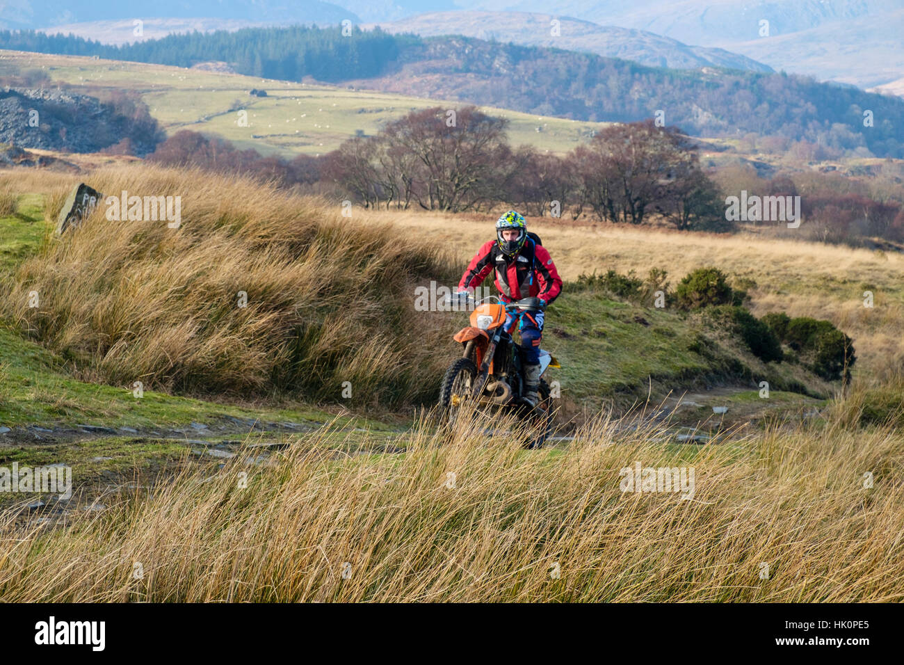 Un uomo a cavallo di un dirt bike su un multi-uso paese via nel Parco Nazionale di Snowdonia. Capel Curig, Conwy, Wales, Regno Unito, Gran Bretagna. Foto Stock