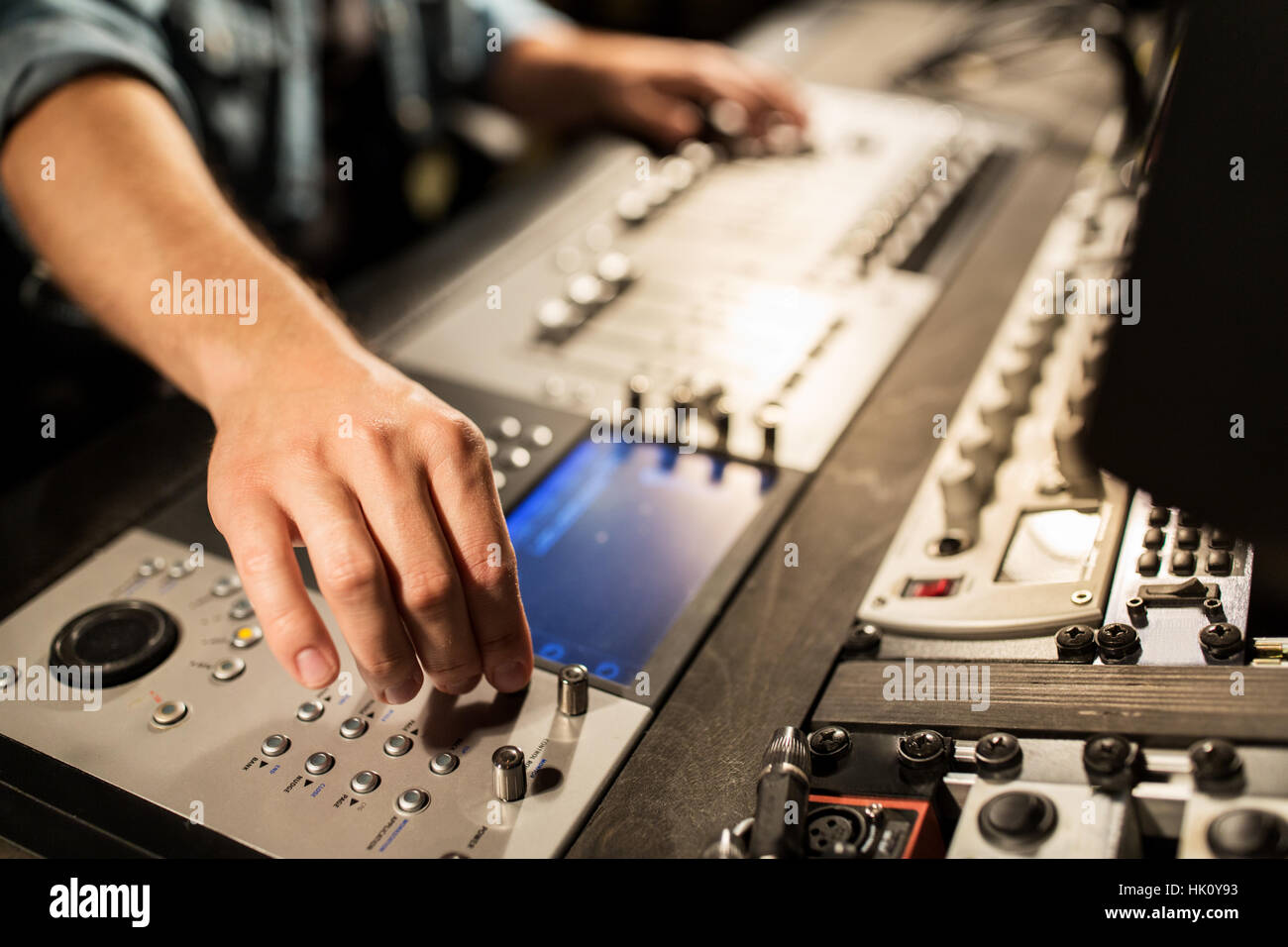 Uomo che utilizza la console di miscelazione in music studio di registrazione Foto Stock